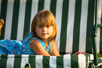 Little beautiful child lying on a swing