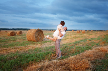 Naklejka na ściany i meble young loving couple on wheat field