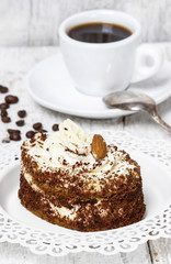 Tiramisu cake on white plate. Wooden background, selective focus