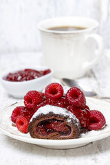 Swiss roll (roulade) with raspberries on white plate. Selective