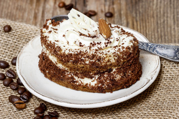 Tiramisu cake on hessian napkin. Coffee beans around.