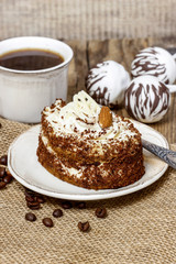 Tiramisu cake on hessian napkin. Coffee beans around.