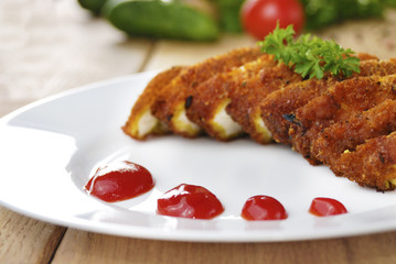 Fried chicken nuggets on the plate on the wooden table