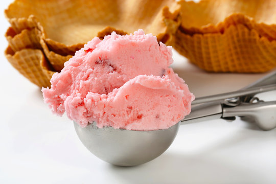 Scoop of strawberry ice cream and waffle baskets
