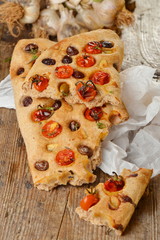 Focaccia with tomato, fresh garlic and black olives.
