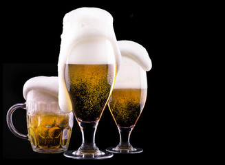 Frosty glass of light beer on black background