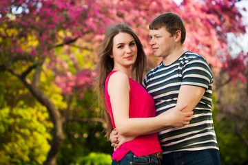 Fototapeta premium loving couple in the blossoming apple orchard