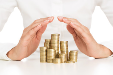 Savings protection, close up of female hands covering stack of g