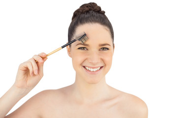 Fototapeta premium Smiling sensual model using eyebrow brush