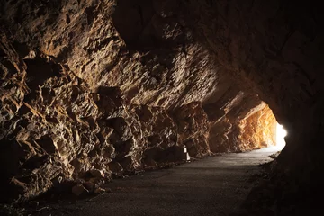 Foto op Plexiglas Tunnel Lege weg gaat door de grot met gloeiend einde
