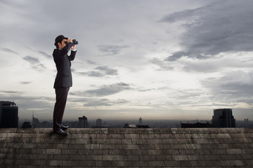 Businessman using binoculars.