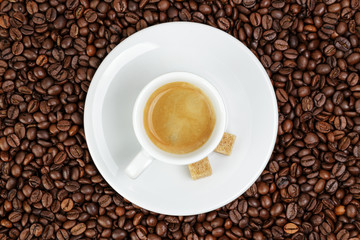 fine espresso in cup on coffee beans