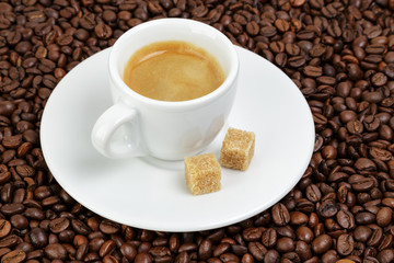 fine espresso in cup on coffee beans