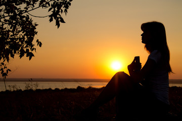silhouette of a girl reading at sunset