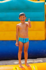 Smiling boy on blue swimming trunks during his summer vacation