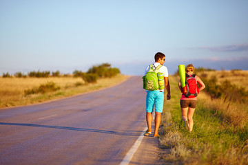 Fototapeta premium young people traveling hitchhiking. summer field
