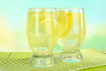 Delicious lemonade on table on light blue background