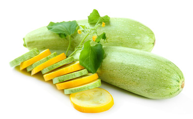 Sliced and whole raw zucchini, isolated on white