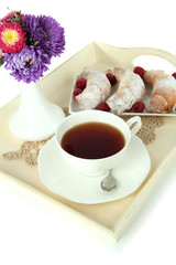 Cup of tea with cakes on wooden tray isolated on white