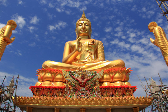 Big golden Buddha statue on blue sky