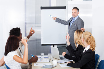 Businesspeople Looking At Man Explaining