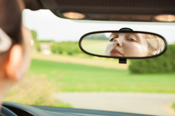 Woman Looking At Mirror In Car