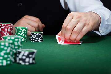 Human hand of poker player with cards and chips