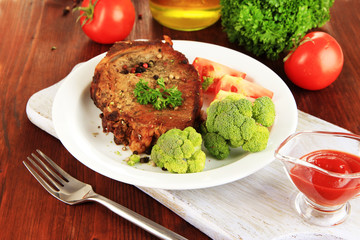 Piece of fried meat on plate on wooden table close-up
