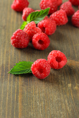 Ripe sweet raspberries on wooden background