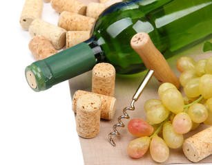 Bottle of wine, grapes and corks, isolated on white