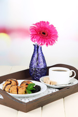 Wooden tray with breakfast, on wooden table, on light