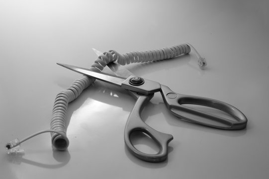 Telephone cord being cut by scissors