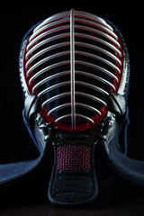 Vertical shot of kendo helmet over dark background, close-up