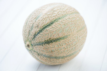 Cantaloupe melon over white wooden boards, studio shot