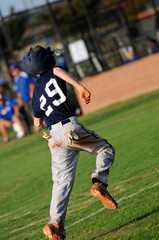 Teen baseball player running home
