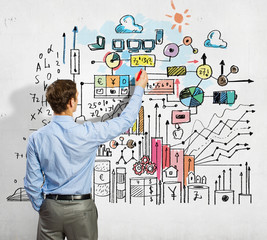 Businessman drawing sketches on wall