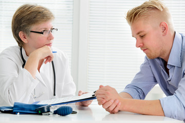 Doctor talking to her male patient at office