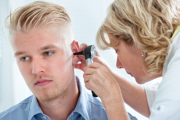 ENT physician looking into patient's ear with an instrument
