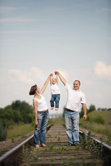 happy parents with baby on railroad