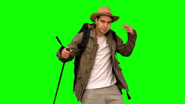 Man wiping his forehead while he is trekking on green screen