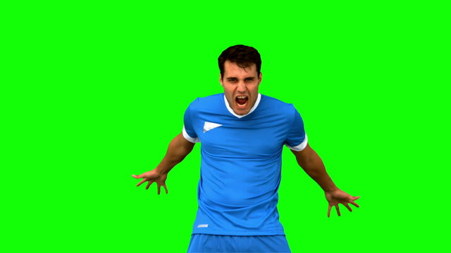 Angry football player holding his head on green screen