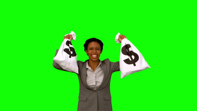 Businesswoman holding money bags on green screen