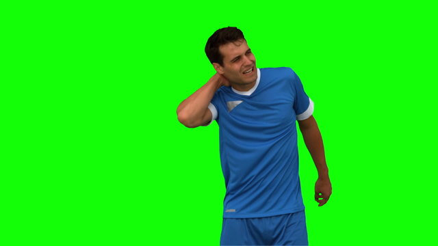 Football player suffering from neck pain on green screen