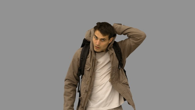 Handsome man walking towards the camera on grey screen