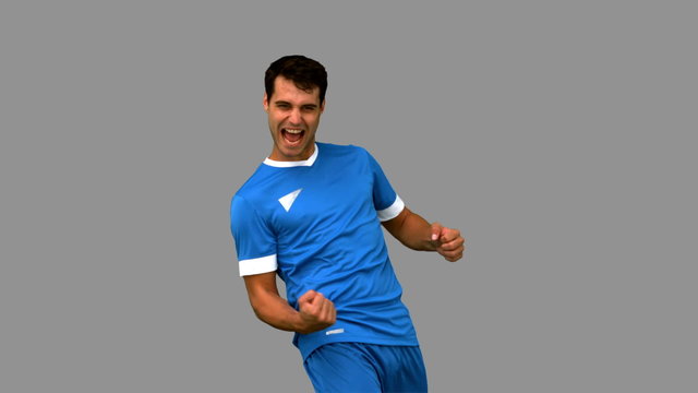 Cheerful football player gesturing on grey screen