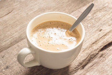 Creamy coffee on wood table.
