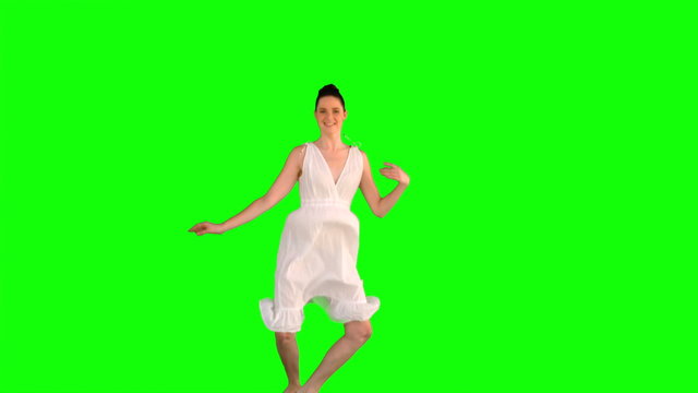 Cheerful model in white dress jumping