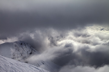 Off-piste slope and snowy rocks in bad weather