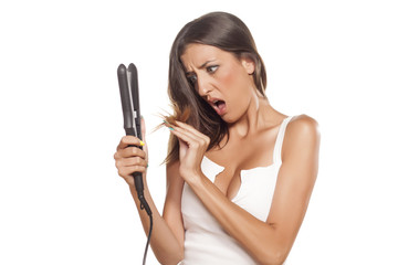 girl straightens her hair and looking shocked