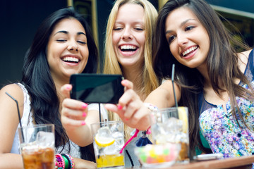 three friends taking photos with a smartphone